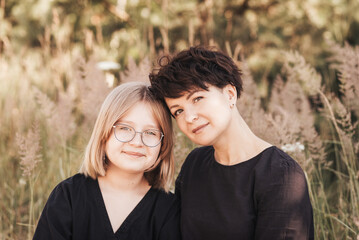 Obraz premium Mom hugging daughter teenager on a background of nature