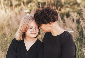 Fototapeta premium Mom hugging daughter teenager on a background of nature