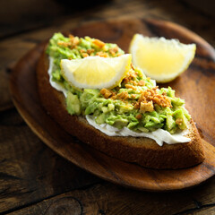 Homemade avocado toast with cream cheese and lemon