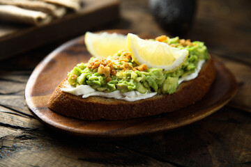 Homemade avocado toast with cream cheese and lemon