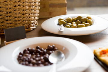 Different types of olives served on white plates