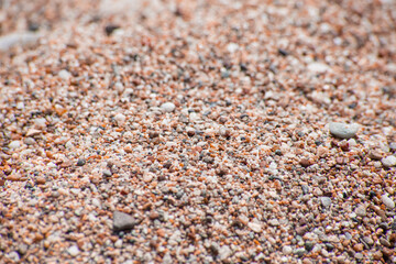 Small sea pebbles with stones with a reddish tint