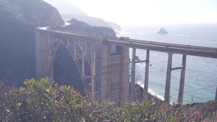 Obraz premium Bixby creek bridge, arch architecture. Pacific coast highway 1 landmark. Historic scenic Cabrillo road. Coastal road trip, journey or travel by ocean. Canyon in foggy weather. California, Big Sur, USA