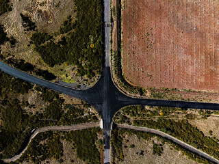winding curve four way road intersection amidst agricultural field