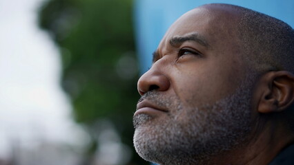 A contemplative black African senior man closing eyes