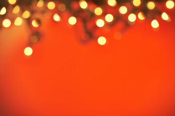 Lets get festive. Closeup shot of a string of Christmas lights on a red background.