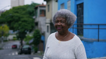 A Brazilian latin older woman in 70s with gray hair outside in urban street tracking shot
