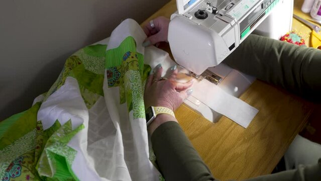Using a sewing machine to attach the border around the edge of the joined quilt blocks