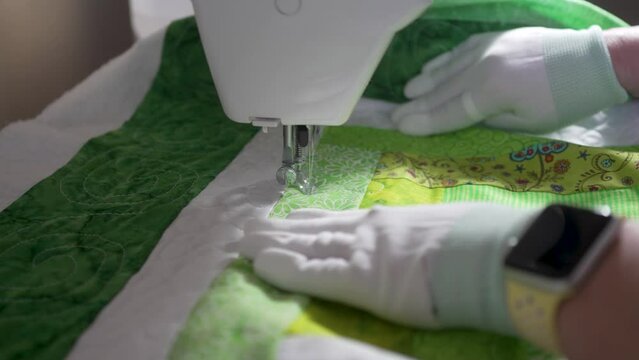 Stitching in an intricate pattern on a homemade quilt using a sewing machine - slow motion