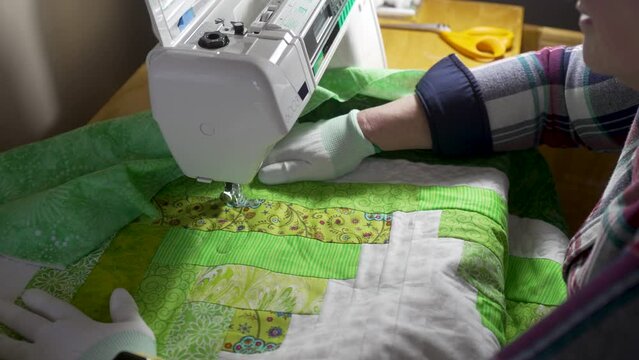 Sewing a pattern on a homemade quilt with a sewing machine - slow motion