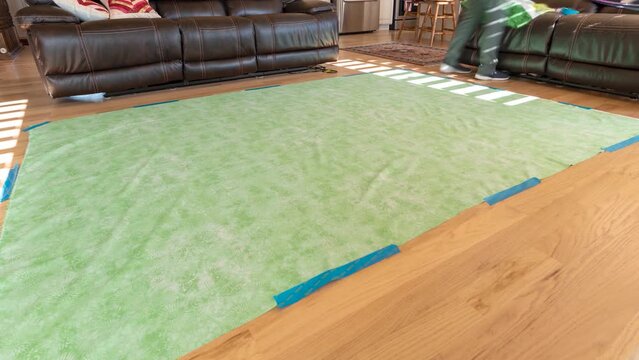 Laying out the bottom, backing and quilt top on the floor and then gluing or basting them together before quilting on a pattern - time lapse
