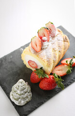 This roll cake contains strawberries and whipped cream.