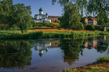Fototapeta na wymiar View of the Church of Epiphany s Zapskovya on the bank of the Pskova River on a sunny summer day, Pskov, Russia