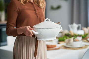 Unrecognizable woman standing and holding a soup vase
