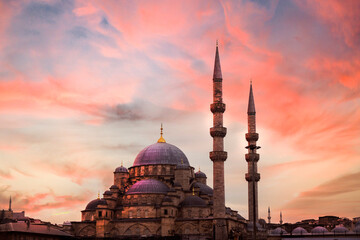 Mosque minaret stretching into the sky, Photo taken from the side at sunset. New mosque Eminonu Turkey.