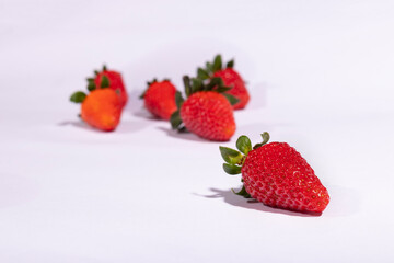Red strawberry with blurred background with other strawberries.