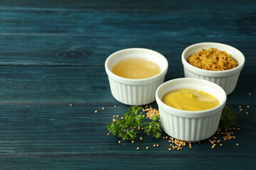 Bowls with sauces on wooden table, space for text