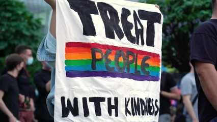 LGBT equality march. Fight for LGBTQ+ rights. Rainbow flags, banners and masks. Struggle for LGBT rights during coronavirus pandemic. Treat people with kindness banner.
