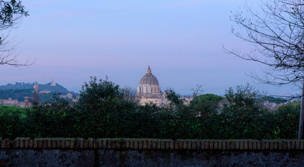 View of Saint Peter Basilica cupola, or Cupolone, from Doria Pamphilj gardens at sunset in Rome,...