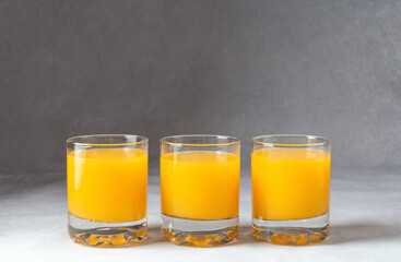 Orange juice in glasses on a gray background. Concept. Photo