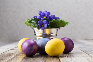 Easter eggs on a wooden table and flowers in a vase. Multicolored eggs. Easter.Photo