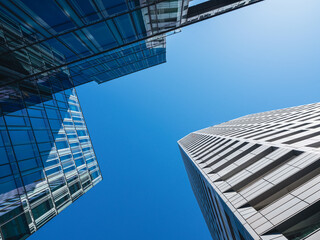 Fototapeta na wymiar Bottom-up view of modern skyscrapers over blue sky background