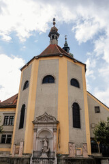Linz, Austria, 27 August 2021: Medieval catholic Baroque Stadtpfarrkirche with tower, Parish Church at Pfarrplats, old town street at sunny summer day, Facade of stone gothic and renaissance buildings