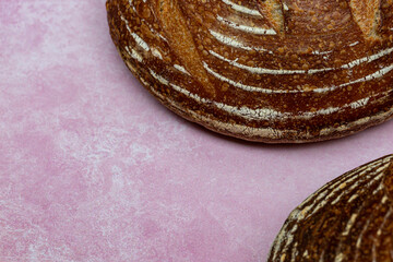Looking down at sourdough bread against a pink background