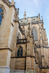 Linz, Austria, 27 August 2021: Facade of medieval catholic stone gothic New Cathedral of Immaculate Conception with arch, old town street at sunny summer day, lancet windows and carved statues