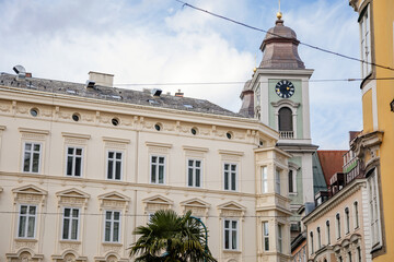 Obraz premium Linz, Austria, 27 August 2021: Baroque Old Cathedral or Alter Dom with two towers, Church of Ignatius, Hauptplatz or main square at sunny summer day, Facade of stone colorful historical buildings