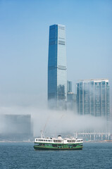 Skyscraper and ferry in Victoria harbor of Hong Kong city