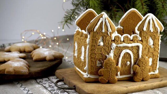 Gingerbread house Christmas homemade baking. Gingerbread Man. astle with white icing. Cookies in the shape of a Christmas tree and snowflakes on the table. Food for dessert. Winter gingerbread.