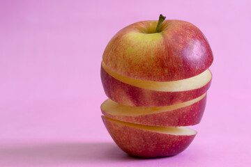 Floating levitating ripe apple on pink background. Vitamins, healthy diet concept. Minimal fruit idea. Sliced apple floating in the air. Creative concept with flying fruits.