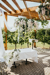 Wedding. Banquet. Chairs and honeymooners table decorated with candles. Beautiful decoration, beautiful flowers.