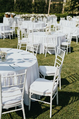Wedding. Banquet. Chairs and honeymooners table decorated with candles. Beautiful decoration, beautiful flowers.