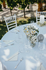 Wedding. Banquet. Chairs and honeymooners table decorated with candles. Beautiful decoration, beautiful flowers.