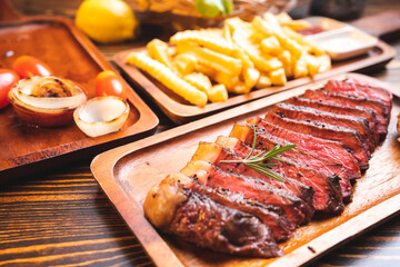 Beef steak serve on wooden plate with rosemary herb and pepper, fresh grilled meat food made for dinner, picanha or sirloin beef fillet cut with salt and vegetable