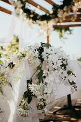 Wedding. Banquet. Chairs and honeymooners table decorated with candles. Beautiful decoration, beautiful flowers.