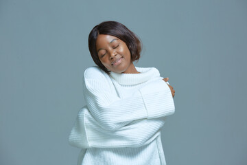Peaceful pretty african american young woman embrace herself smiling. Self love, self-care, body positive concept