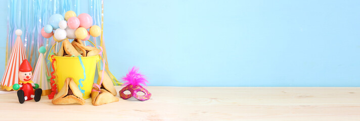 Purim celebration concept (jewish carnival holiday) over wooden table