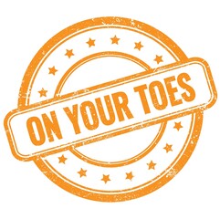 ON YOUR TOES text on orange grungy round rubber stamp.