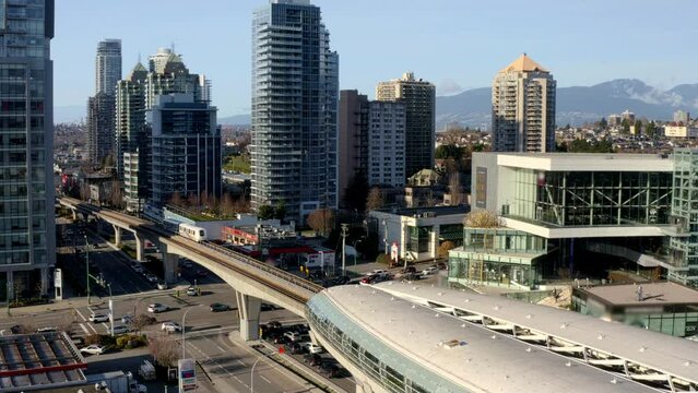 High-rise Buildings In Burnaby City With Train Leaving At Brentwood Town Centre Station In Canada. - aerial