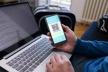 Man checking his expiration date International certificate of vaccination on smartphone while waiting to hit the road. Smartphone display on app mobile vaccinated COVID-19 or coronavirus certificate.