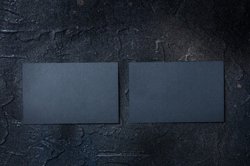 Two black business cards mockup, front and back, on a dark background, a template for design...
