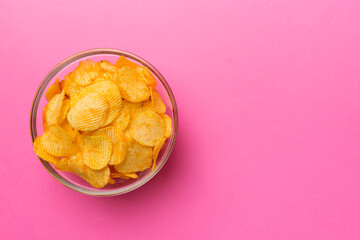 Potato chips on bowl isolated on colored background. Delicious crispy potato chips in bowl. Space for text. Top view