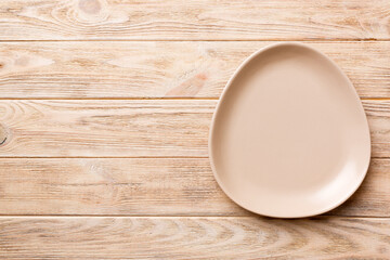 Top view of empty pink plate on wooden background. Empty space for your design