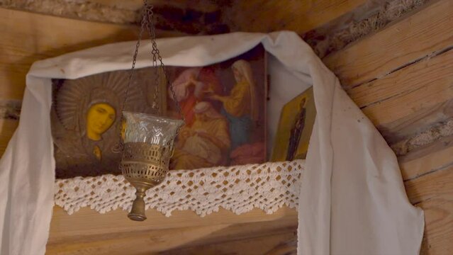 Dnieper Russian things in a wooden house made of struba: an iconostasis, a goddess, a red corner: Orthodox icons in the corner, a lamp, a lamp, lacy white napkins. Close-up, during the day