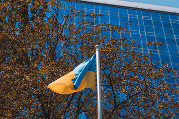 The national flag of Ukraine flutters in the wind. The national symbol of the Ukrainian people on the building. City Dnipro