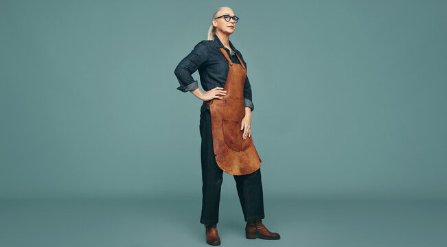 Contemplative female goldsmith standing in a studio - Powered by Adobe