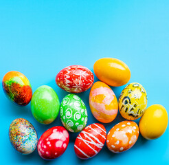 closeup, many beautiful painted Easter eggs as blue background. the concept for good friday, easter monday, spring full moon. copy space on top for text or design. top view, nobody, selective focus